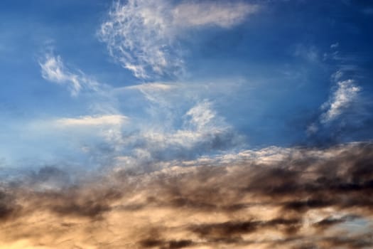 Beautiful panorama of orange and yellow clouds at sunrise and sunset in a blue sky