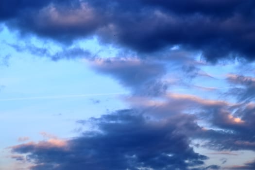 Beautiful panorama of orange and yellow clouds at sunrise and sunset in a blue sky