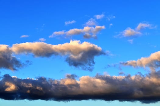 Beautiful panorama of orange and yellow clouds at sunrise and sunset in a blue sky