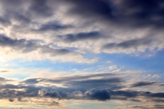 Beautiful panorama of orange and yellow clouds at sunrise and sunset in a blue sky