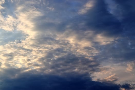 Beautiful panorama of orange and yellow clouds at sunrise and sunset in a blue sky