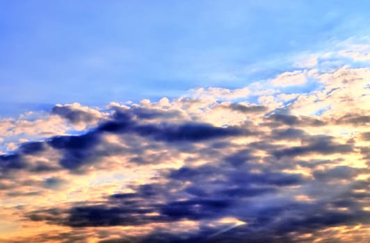 Beautiful panorama of orange and yellow clouds at sunrise and sunset in a blue sky