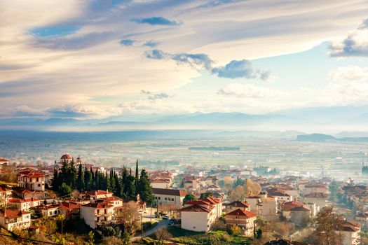 Greek town sunset panorama with red roof houses, valley and mountains in the background, Kalambaka, Thessaly, Greece