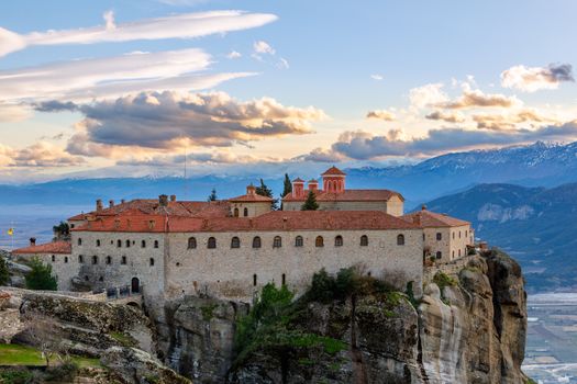 Agios Stephanos or Saint Stephen monastery located on the huge rock with mountains and town landscape in the background, Meteors, Trikala, Thessaly, Greece