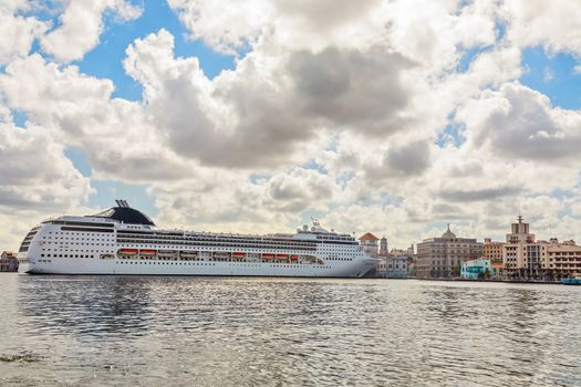 Big touristic cruise ship docked in port of Havana with blue sky and clouds panorama, Cuba