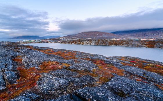 Autumn greenlandic orange tundra landscape with lake and mountains in the background, Nuuk, Greenland