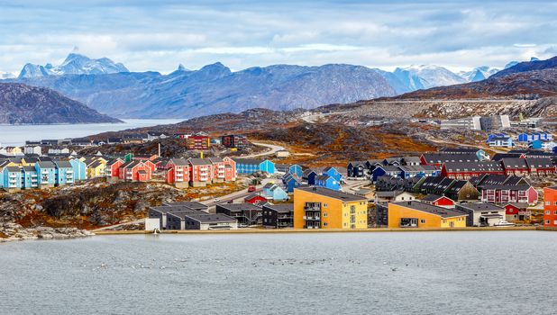 Colorful Inuit buildings in residential district of Nuuk city with lake in the foreground, Greenland
