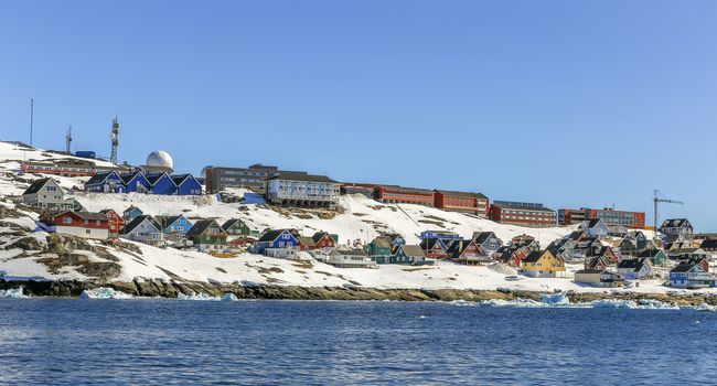 Lots of Inuit huts and living buildings scattered on the rocky coast along the fjord, Nuuk city, Greenland