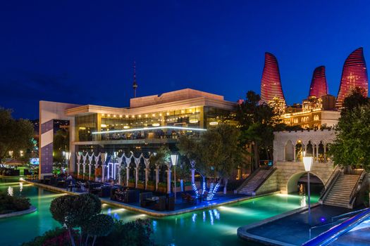 Evening view of central city park with neon highlighted buildings and skyscrapers, Baku, Azerbaijan