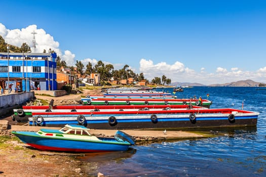 Long colorful passenger ferry boats on the coast of Titicaca, Strait of Tiquina, Tiquina, Bolivia, South America