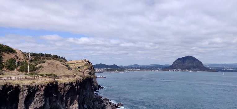 Landscape view of songaksan and Sanbang-san mountain separated by ocean in Jeju Island, South Korea