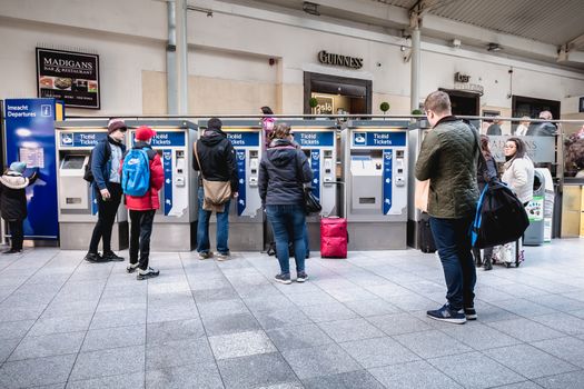 Dublin, Ireland - February 15, 2019: Passengers buying a ticket in the Connolly DART train station (Staisiun ui Chonghaile) on a winter day