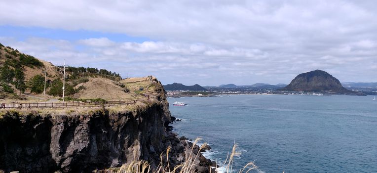 Songaksan and Sanbang-san mountain divided by ocean and joined by land in Jeju Island, South Korea