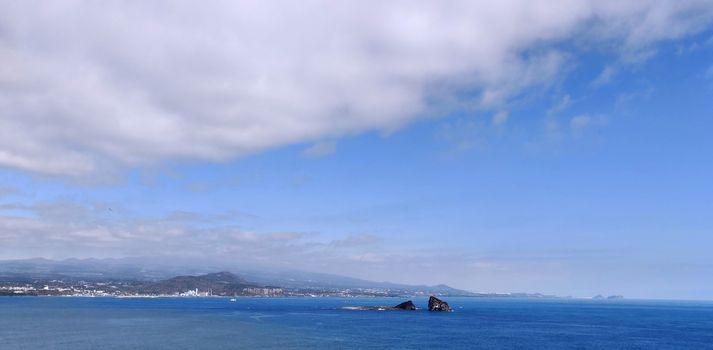 Bright blue never-ending sea with white clouds in the blue sky in Jeju Island, South Korea
