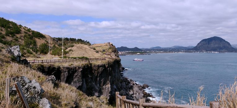 Beautiful Landscape view of songaksan and Sanbang-san mountain separated by ocean in Jeju Island, South Korea