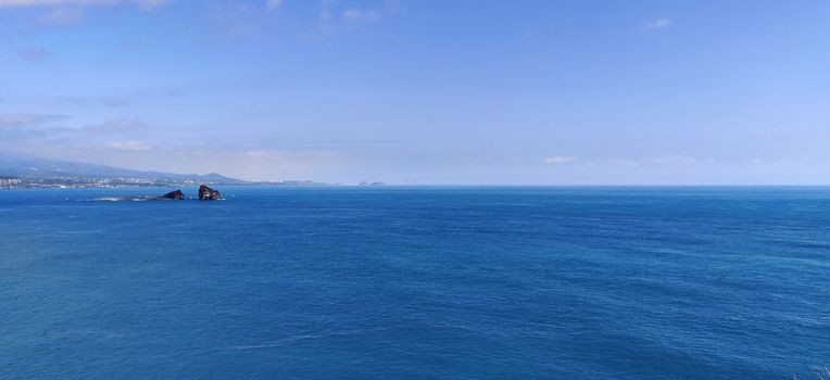 Wide angle shot of the brightest blue empty ocean and sky in Jeju Island, South Korea