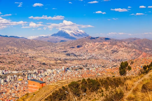 View to the snow cap of Illimani peak and valley full of living houses, El Alto, La Paz city, Bolivia