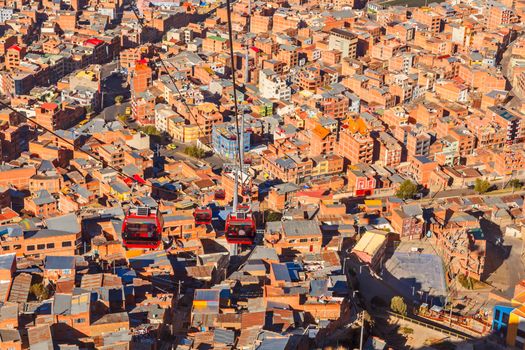 Cable cars or funicular system over orange roofs and buildings of the Bolivian capital, La Paz, Bolivia