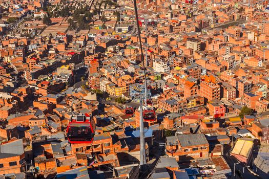 Cable cars or funicular system over orange roofs and buildings of the Bolivian capital, La Paz, Bolivia