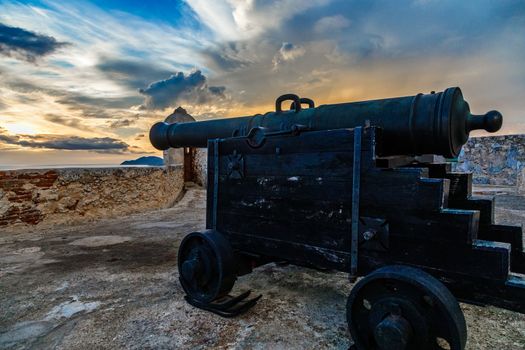 Old Spanish Cannon on the carriage in San Pedro de La Roca fort walls, with Caribbean sea sunset view, Santiago De Cuba, Cuba