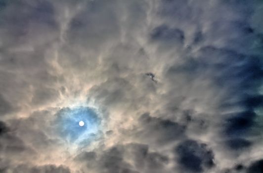 Beautiful view at bright sunbeams with some lens flares and clouds in a blue sky