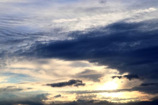 Beautiful view at bright sunbeams with some lens flares and clouds in a blue sky