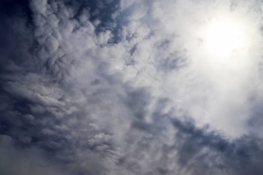 Beautiful view at bright sunbeams with some lens flares and clouds in a blue sky