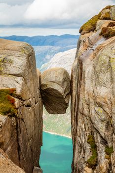 Kjeragbolten, the stone stuck between two rocks with fjord in the background, Lysefjord, Norway