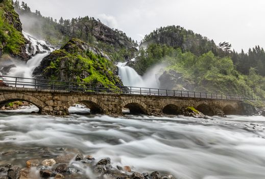 Latefoss twin waterfalls streams under the stone bridge archs, Odda, Hordaland county, Norway