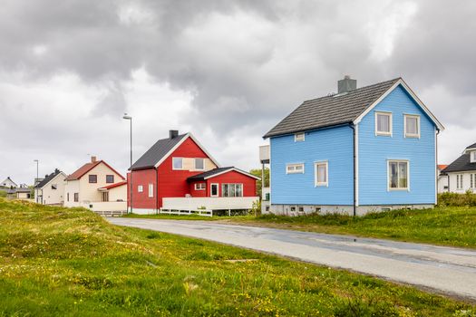 Blue, red and white norwegian houses along the road in Andenes village, Andoy Municipality, Vesteralen district, Nordland county, Norway