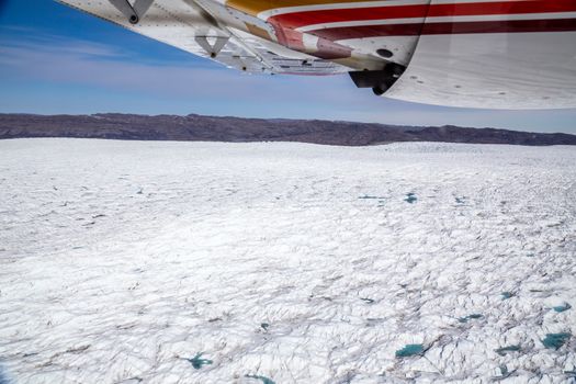 Greenlandic melting ice sheet glacier aerial view from the plane, near Kangerlussuaq, Greenland