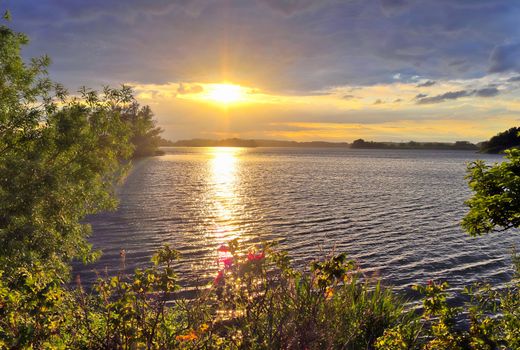 Beautiful and romantic sunset at a lake in stunning yellow and orange colors