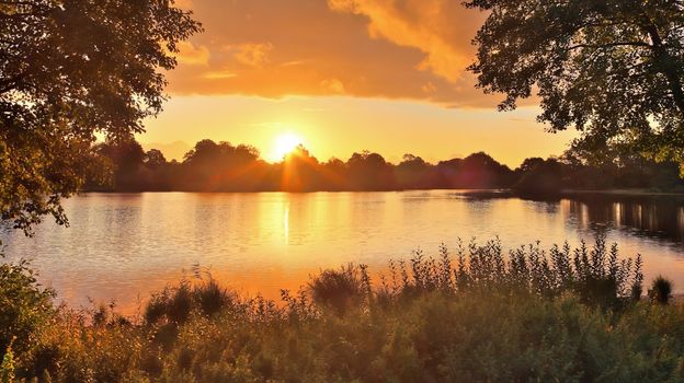 Beautiful and romantic sunset at a lake in stunning yellow and orange colors