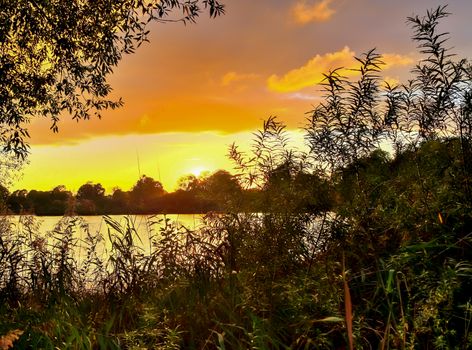 Beautiful and romantic sunset at a lake in stunning yellow and orange colors