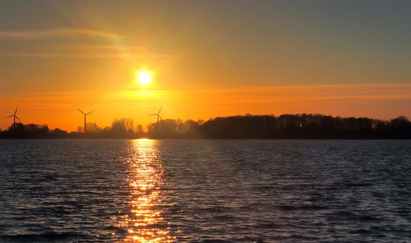 Beautiful and romantic sunset at a lake in stunning yellow and orange colors