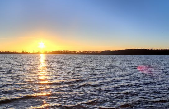 Beautiful and romantic sunset at a lake in stunning yellow and orange colors