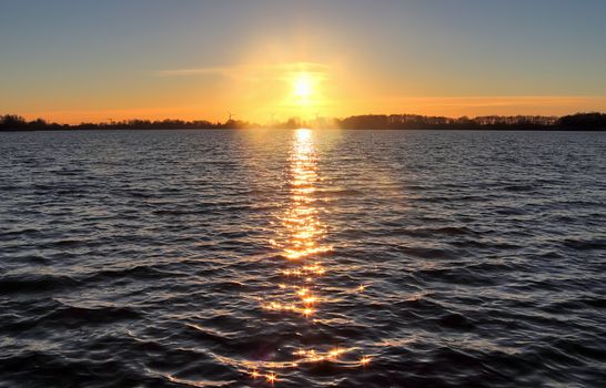 Beautiful and romantic sunset at a lake in stunning yellow and orange colors