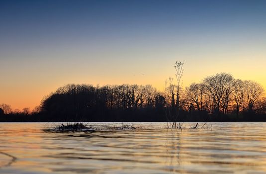 Beautiful and romantic sunset at a lake in stunning yellow and orange colors