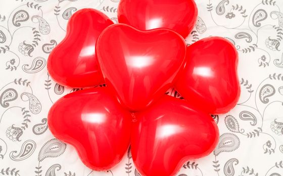Composition of red heart shaped balloons on a blanket. Concept for romanticism