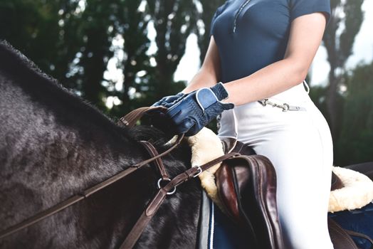 young girl jockey trains horse to horse racing at summer. equestrian