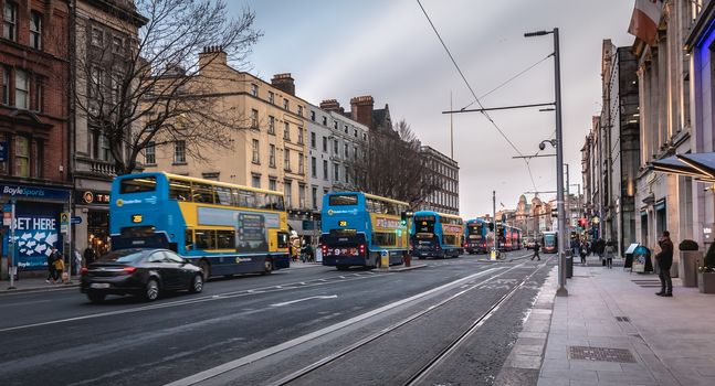 Dublin, Ireland - February 11, 2019: People walking down a shopping street with typical Irish architecture in the historic city center on a winter day