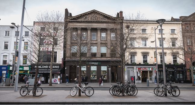 Dublin, Ireland - February 11, 2019: Architecture detail and street ambiance in front of the shops with the typical architecture of O Connell Street where people are walking on a winter day