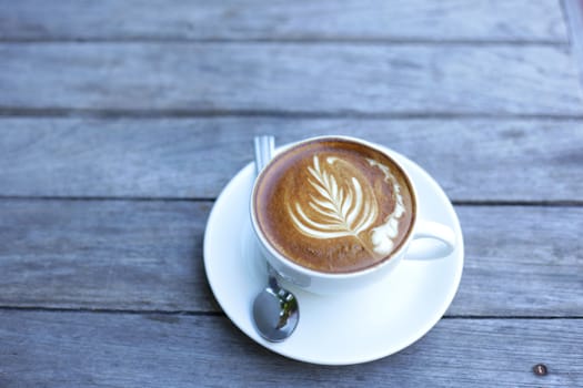 White Latte coffee cup on weathered pallet wooden desk top view