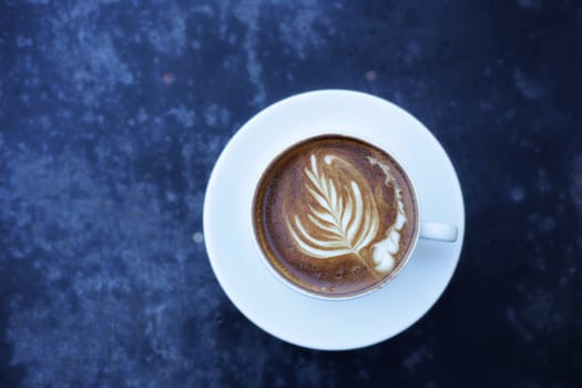 White Latte coffee cup on blue grunge mortar desk top view