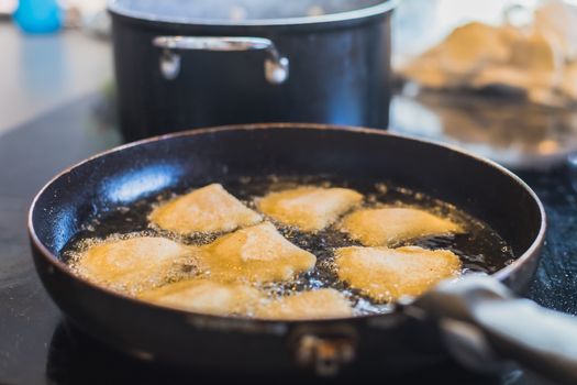 fried portuguese or brazilian rissoles in a pan in a kitchen