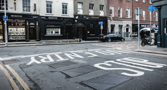 Dublin, Ireland - February 11, 2019: People walking down a shopping street with typical Irish architecture in the historic city center on a winter day