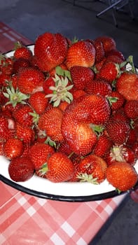 Ripe juicy red strawberry in a white cup. strawberry crop.