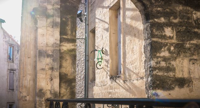 Montpellier, France - January 2, 2019: child's bike hanging on a wall in the historic city center by an anonymous artist with the pseudonym BMX