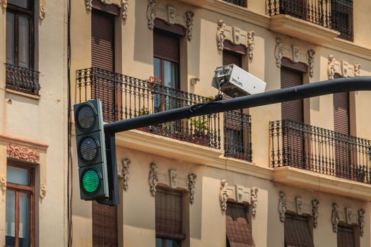 Valencia, Spain - June 16, 2017: detail of a tricolor traffic light radar in the city center on a summer day