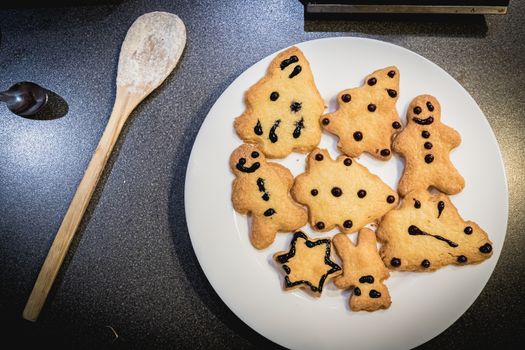 Christmas shortbread cookies in the shape of fir trees, stars and snowmen in a white plate